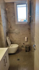 a bathroom with a toilet and a window at Aegean dream house in Ofrínion
