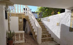 a white stairway with a white door and a stair case at Ferienwohnung mit Privatpool Casa Wende in Benaguacil +1 photo