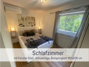 a small bedroom with a bed and a window at OLIVE - Ruhe & Entspannung in 2-Zi-Fewo mit Garten-Whirlpool, Terrasse & Hund willkommen by FerienWohnenAmSee in Überlingen