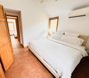 una camera da letto con un letto bianco in una stanza di Cozy cottage by the beach a Hampton Bays