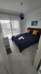 a bedroom with a blue bed and a purple lamp at Aegean dream house in Ofrínion +22 photos