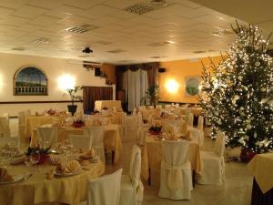 a banquet hall with white tables and christmas trees at Hotel Il Vigneto in Gattinara