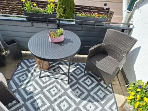 a table and chairs on a patio with flowers at Chalet an der Bode - Schicke 3 Zi Fewo mit Balkon in Braunlage +40 photos