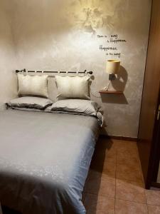 a bedroom with a bed and a writing on the wall at La casa di Penelope in Civita Castellana