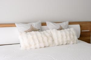 a white pillow on a bed with three pillows at Casa da Tininha in Couto +11 photos