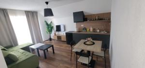 a kitchen and living room with a table and a couch at Anti-Age Apartmani in Bijeljina