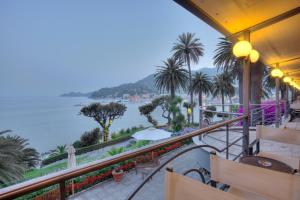 a balcony with a view of the water and palm trees at Hotel Continental in Santa Margherita Ligure