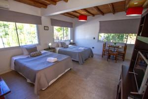 a bedroom with two beds and a table and chairs at Gasparetto Lofts Mendoza in Godoy Cruz