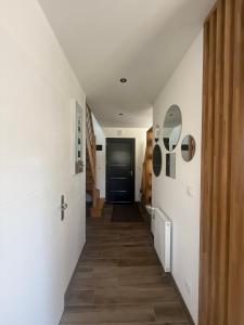 un corridoio con pareti bianche e una porta nera di Les Oliviers a Fort-Mahon-Plage Altre 30 foto