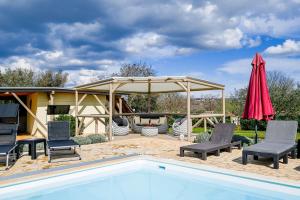 a pool with chairs and a pavilion with a fire pit at Bella di Campo in Rovinj