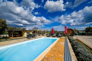 a pool with chairs and umbrellas next to a house at Bella di Campo in Rovinj