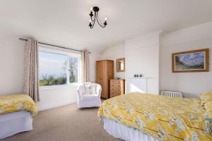 a bedroom with a bed and a window and a chair at Cosy country cottage, nearby beaches attractions A55 in Llysfaen