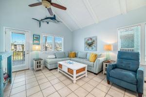 a living room with blue couches and a ceiling fan at Paradise Duplex A in Gulf Shores