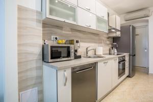 a kitchen with white cabinets and a microwave at Villa Ines in Komiža