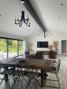 una sala da pranzo con tavolo e sedie in legno di La Villa des Chênes ad Audenge