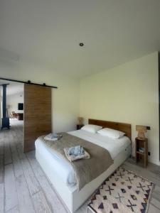 una camera da letto con un grande letto bianco e uno specchio di La Villa des Chênes ad Audenge