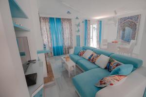 a living room with a blue couch and a television at Casa Melina in Cala del Moral