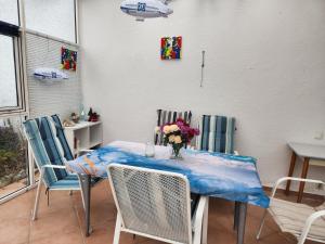 a table with chairs and a vase of flowers on it at Sonnenschein1R in Friedrichshafen