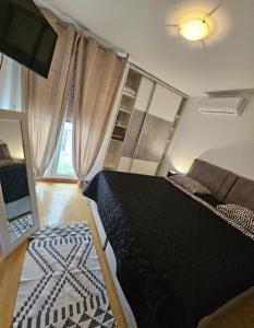 ein Schlafzimmer mit einem schwarzen Bett und einem Sofa in der Unterkunft Beautiful Apartment, Close to Beach in Split