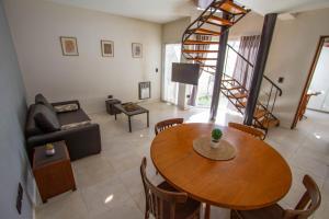 a living room with a wooden table and a couch at Gasparetto Lofts Mendoza in Godoy Cruz