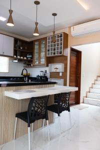 a kitchen with a white table and black chairs at Casa juçara lençóis in Barreirinhas +7 photos