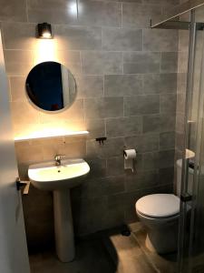 a bathroom with a sink and a toilet and a mirror at Quinta das Lameiras in Sao Pedro de Tomar