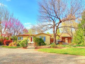 ein gelbes Haus mit einem Baum im Hof in der Unterkunft Cottonwood Cottage in Moab