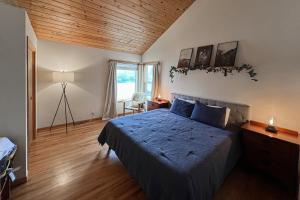 a bedroom with a bed and a wooden ceiling at Siuslaw River House in Mapleton