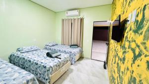 a room with two beds and a mirror at Pousada coração do Jalapão in São Félix do Tocantins