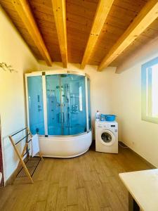 a bathroom with a tub and a washing machine at Holiday House Valpiè in Avola