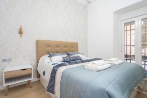 Un dormitorio con una cama grande con toallas. en Falla Loft & Beach, en Cádiz