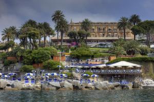 a resort with chairs and umbrellas and a building at Hotel Continental in Santa Margherita Ligure