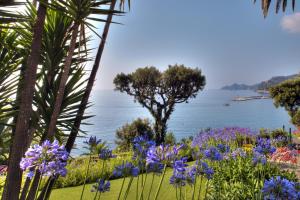 a view of the water from a garden with flowers at Hotel Continental in Santa Margherita Ligure