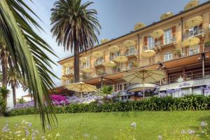 a hotel with palm trees in front of a building at Hotel Continental in Santa Margherita Ligure