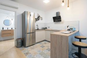 una cocina con refrigerador de acero inoxidable y encimera en Falla Loft & Beach, en Cádiz