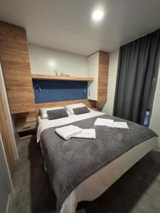 a bedroom with a large bed with towels on it at Ventura mobile home in Biograd na Moru