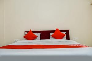 een slaapkamer met een bed met rode kussens bij Super Hotel O Shiv Sai Palace in Bhubaneshwar +18 foto's