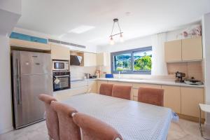 een keuken met een tafel, stoelen en een koelkast bij Villa Casa Luz 2 in Bodrum City