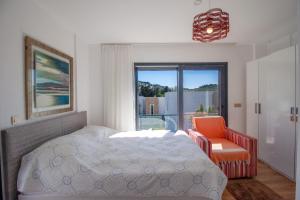 een slaapkamer met een bed, een stoel en een raam bij Villa Casa Luz 2 in Bodrum City +26 foto's