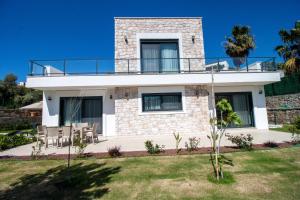 een huis met een balkon erbovenop bij Villa Casa Luz 2 in Bodrum City