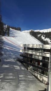 ヴァールにあるImm Pelvoux 1 Studio familial pied des pistesの雪面斜面側の建物