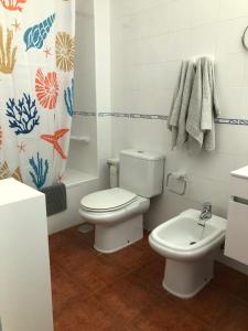 a white bathroom with a toilet and a sink at Casa Chacho, Punta Mujeres in Punta de Mujeres