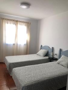 a bedroom with two beds and a window at Casa Chacho, Punta Mujeres in Punta de Mujeres
