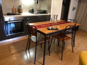 a kitchen with a wooden table with chairs and a vase on it at Studio cinéma in Alès