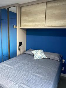 ein blaues Schlafzimmer mit einem Bett mit blauer Wand in der Unterkunft Hotel em CABO FRIO Cond Royale - Av N S Assunção 239, bairro Passagem - un 229 in Cabo Frio