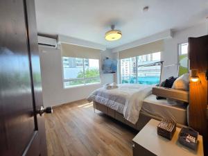 a bedroom with a large bed and two windows at Modern and Lovely Apts in Cinta Costera N#8 in Panama City