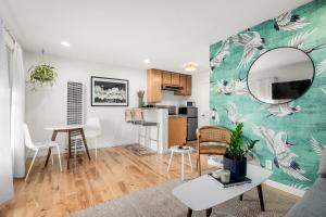a living room and kitchen with a table and a mirror at Swell House Santa Cruz in Santa Cruz