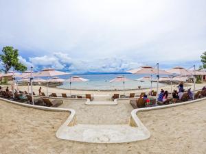 une plage avec des gens assis sur des chaises et des parasols dans l'établissement Family Room with Balcony, à Punta Engaño