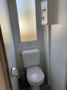 a small bathroom with a toilet and a window at Chez Maxime - E33 - Clim TV Lave-vaisselle - Proche Europa Park et Rulantica in Boofzheim