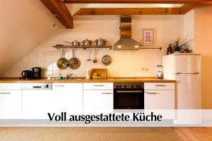 a kitchen with white cabinets and a white refrigerator at Helle 72qm Maisonette Wohnung im Herzen Erfurts mit Kingsize Bett, Smart-TV, etc in Erfurt